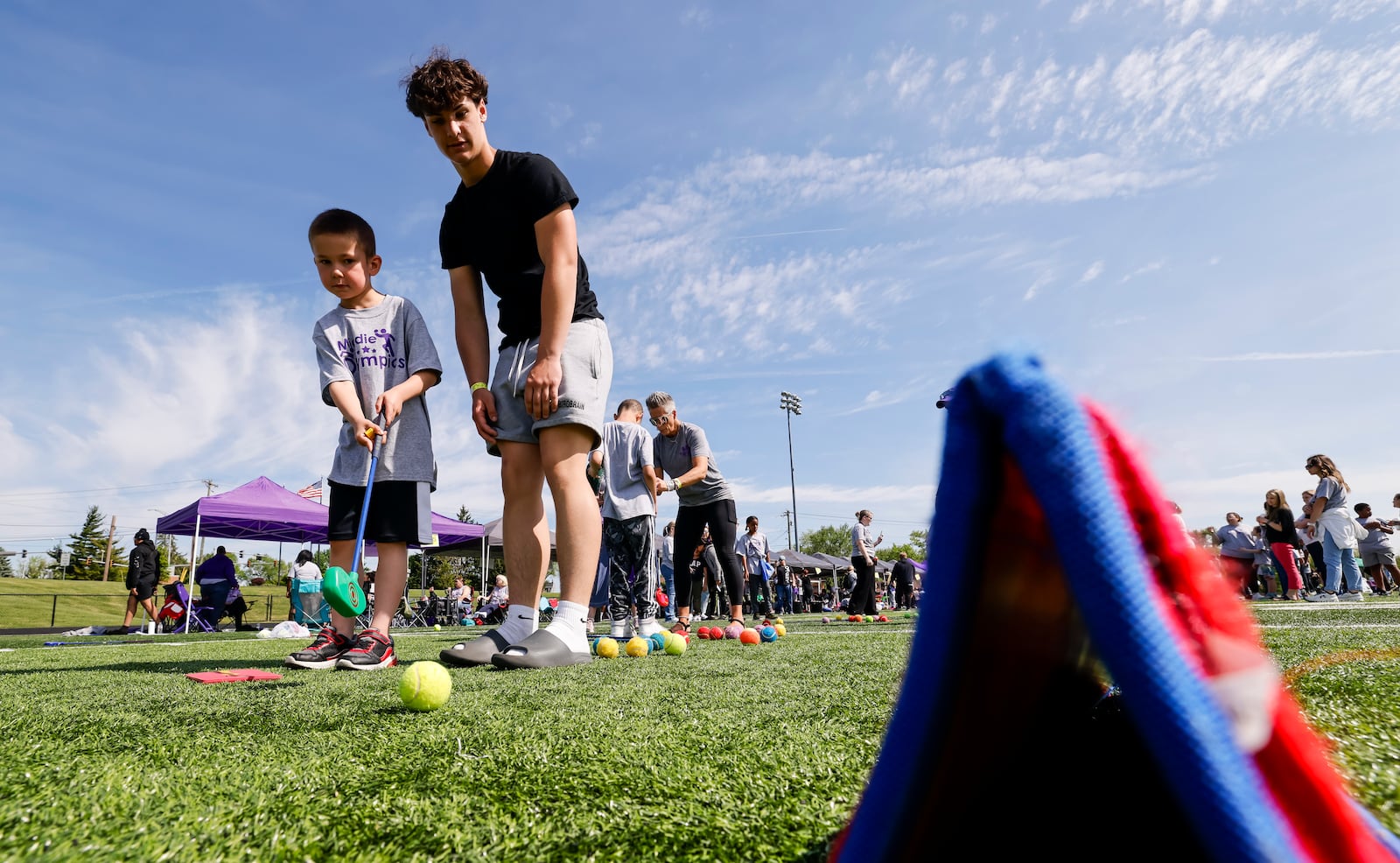 Middletown High School student Will Gibson helps Zander Garner with a golf game as special needs students from Middletown schools participated in Middie Olympics Wednesday, May 7, 2025 at Middletown High School track. NICK GRAHAM/STAFF