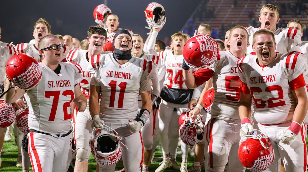 St. Henry players celebrate after defeating Marion Local 24-7 in the Division VII, Region 28 championship on Friday, Nov. 21 at Mercy Health/Wapak VFW Field in Wapakoneta. The Redskins stopped a 76-game winning streak by their Midwest Athletic Conference rival Marion Local. BRYANT BILLING/STAFF