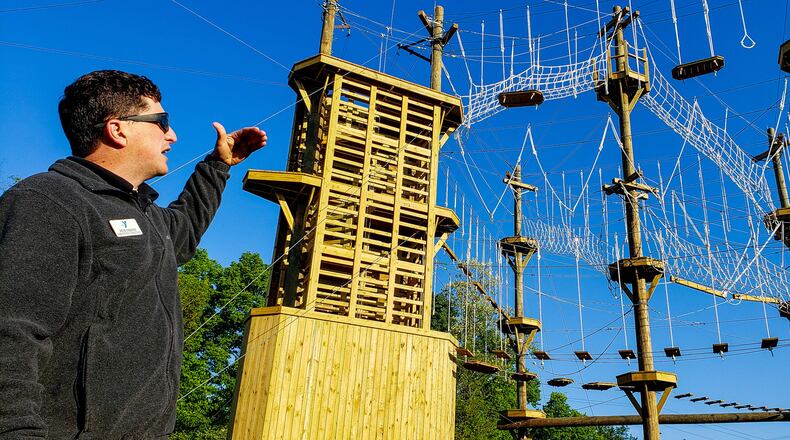 Pete Fasano, executive director of Camp Campbell Gard, shows off the at the Great Miami Valley YMCA's high ropes course now open at Camp Campbell Gard Wednesday, May 15, 2019 on Augspurger Road in St. Clair Township. The course stands nearly fifty feet tall with three levels of elements ranging in difficulty. There is also a climbing wall, zip line, giant swing and more. The course has a universal access system allowing participants with all abilities, including those in wheel chairs, the opportunity to experience it. NICK GRAHAM/STAFF