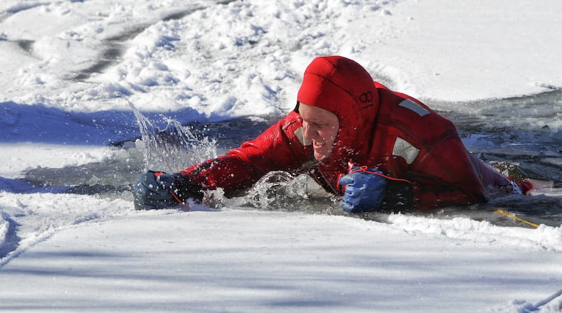 Todd Steinbrunner claws his way out of the water as he and other crews from Middletown Division of Fire participated in water rescue training on the ice covered pond at Smith Park in Middletown Tuesday, February 2, 2021. The department used the pond for several days to practice rescues simulating a person falling through the ice. NICK GRAHAM / STAFF