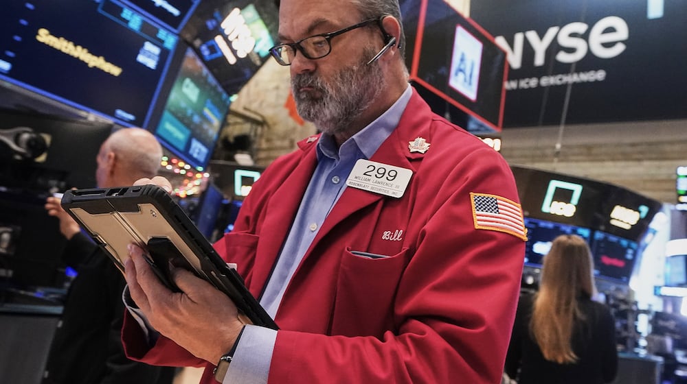 Trader William Lawrence works on the floor of the New York Stock Exchange, Thursday, Dec. 11, 2025. (AP Photo/Richard Drew)