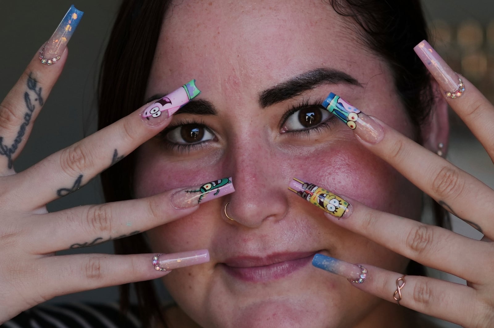 Mariam Camila Sosa strikes a pose to show off her freshly decorated fingernails, at a home-run nail salon in Havana, Cuba, Tuesday, June 24, 2025. (AP Photo/Ramon Espinosa)