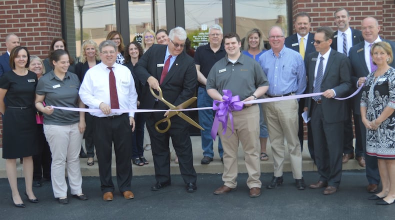 First Merchants Bank officials and employees along with city officials and representatives of the Oxford Chamber of Commerce gathered May 11 for the formal ribbon-cutting at the bank s new location in Stewart Square. Performing the ceremonial cutting is Banking Center Manager Scott Anderson. CONTRIBUTED/BOB RATTERMAN
