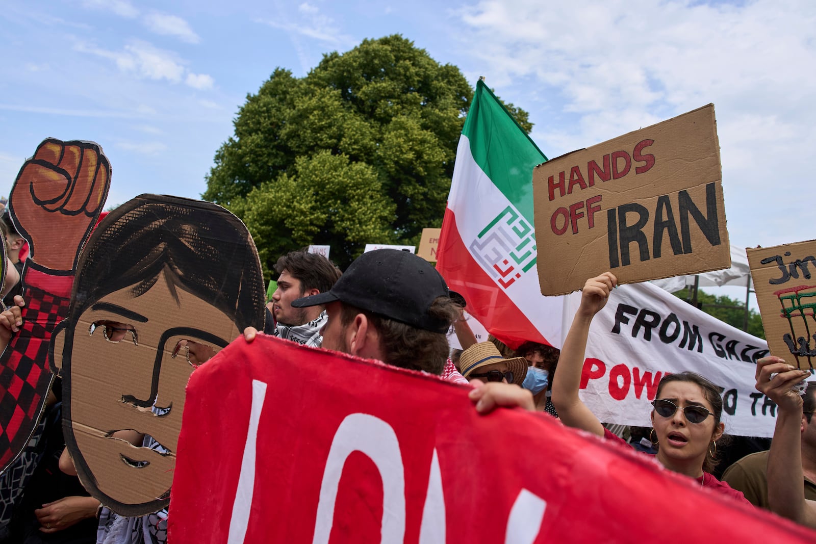 A woman holds a placard during a demonstration ahead of the NATO summit in The Hague, Netherlands, Sunday, June 22, 2025. (AP Photo/Peter Dejong)