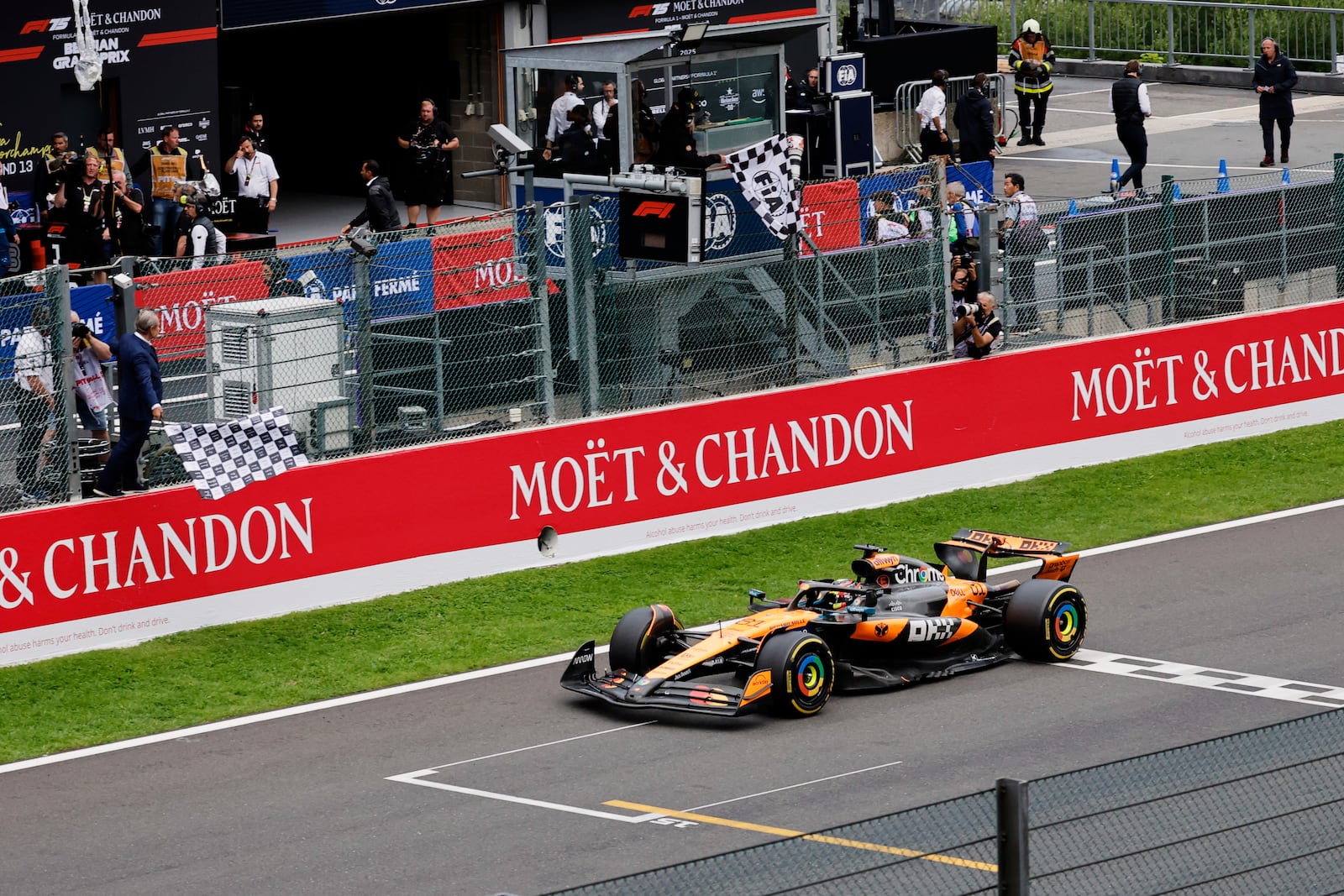 The checkered flag is waved as McLaren driver Oscar Piastri of Australia crosses the finish line to win the Formula One Grand Prix at the Spa-Francorchamps racetrack in Spa, Belgium, Sunday, July 27, 2025. (AP Photo/Geert Vanden Wijngaert)