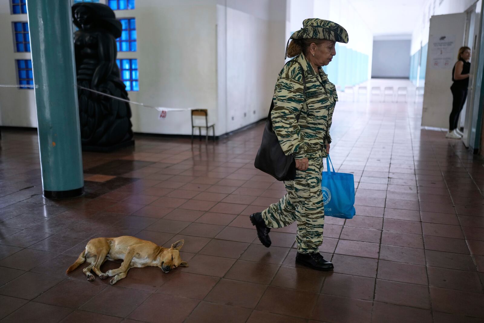 A member of the Bolivarian Militia arrives at a polling station to vote in legislative and local elections in Caracas, Venezuela, Sunday, May 25, 2025. (AP Photo/Ariana Cubillos)