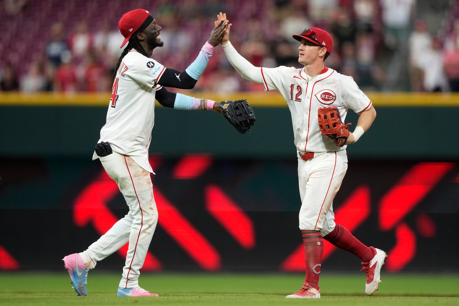 Cincinnati Reds shortstop Elly De La Cruz, left, and left fielder Austin Hays, right, celebrate after winning a baseball game against the Philadelphia Phillies Wednesday, Aug. 13, 2025, in Cincinnati. (AP Photo/Carolyn Kaster)