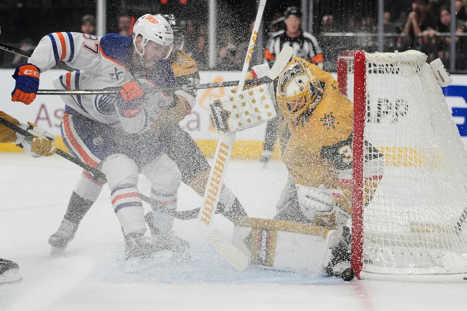 Vegas Golden Knights goaltender Adin Hill (33) stops the puck beside Edmonton Oilers center Connor McDavid (97) during the third period of Game 2 of a second-round NHL hockey playoff series Thursday, May 8, 2025, in Las Vegas. (AP Photo/John Locher)