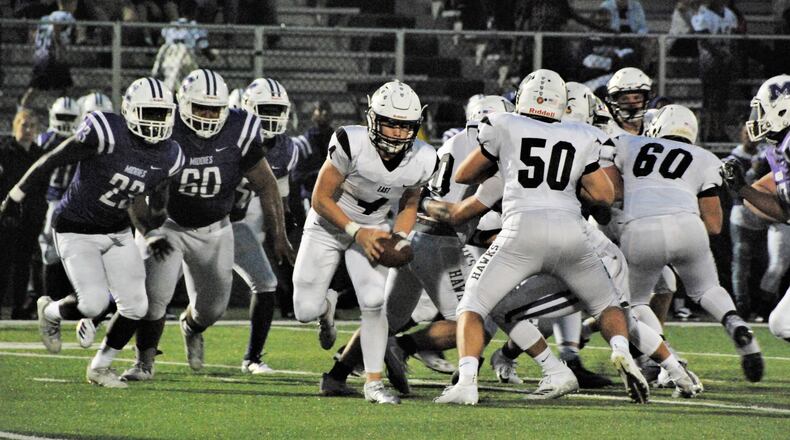 Lakota East quarterback Sean Church (4) gets some blocking help from Sam Florence (50) as Middletown’s Ty Johnson (23), Javen Davis (60) and Kenny Wilson (17) are in pursuit Friday night at Barnitz Stadium in Middletown. East won 32-7. CONTRIBUTED PHOTO BY OLIVER SANDERS