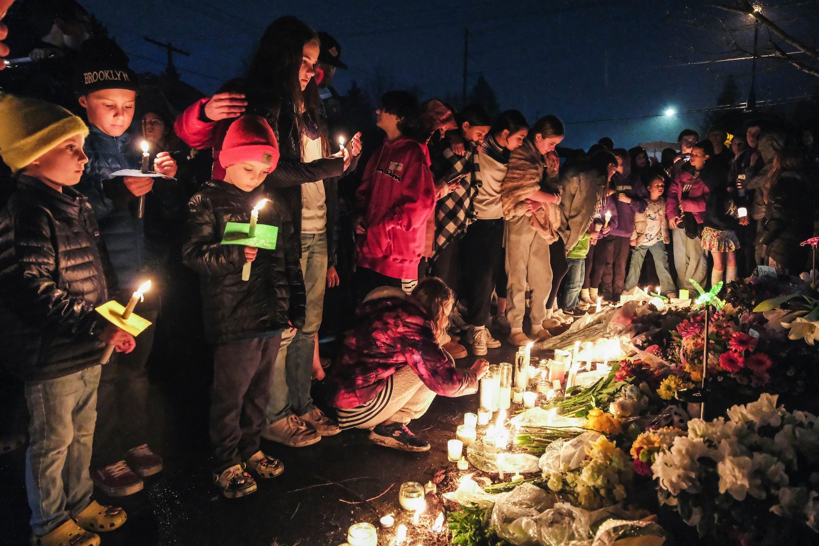 People gather at a vigil, March 22, 2024, in Renton, Wash., for the four people, Andrea Hudson, Matilda Wilcoxson, Eloise Wilcoxson and Boyd "Buster" Brown, who were killed in a car crash. (Ellen M. Banner/The Seattle Times via AP)