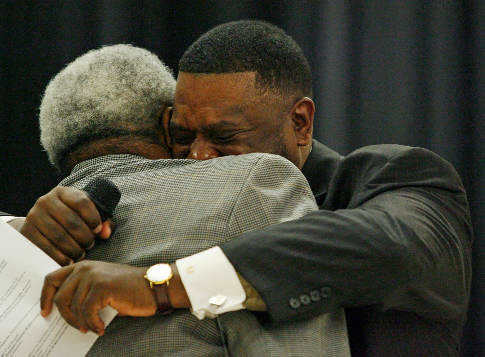 Middletown High School graduate Darren Brown (CQ), right, tears up as he hugs Elmon Prier (CQ) at the Rosa Parks Day assembly Monday, Dec. 7 at Rosa Parks Elementary School in Middletown, Ohio. Prier was one of six Rosa Parks Day honorees recognized during the ceremony.