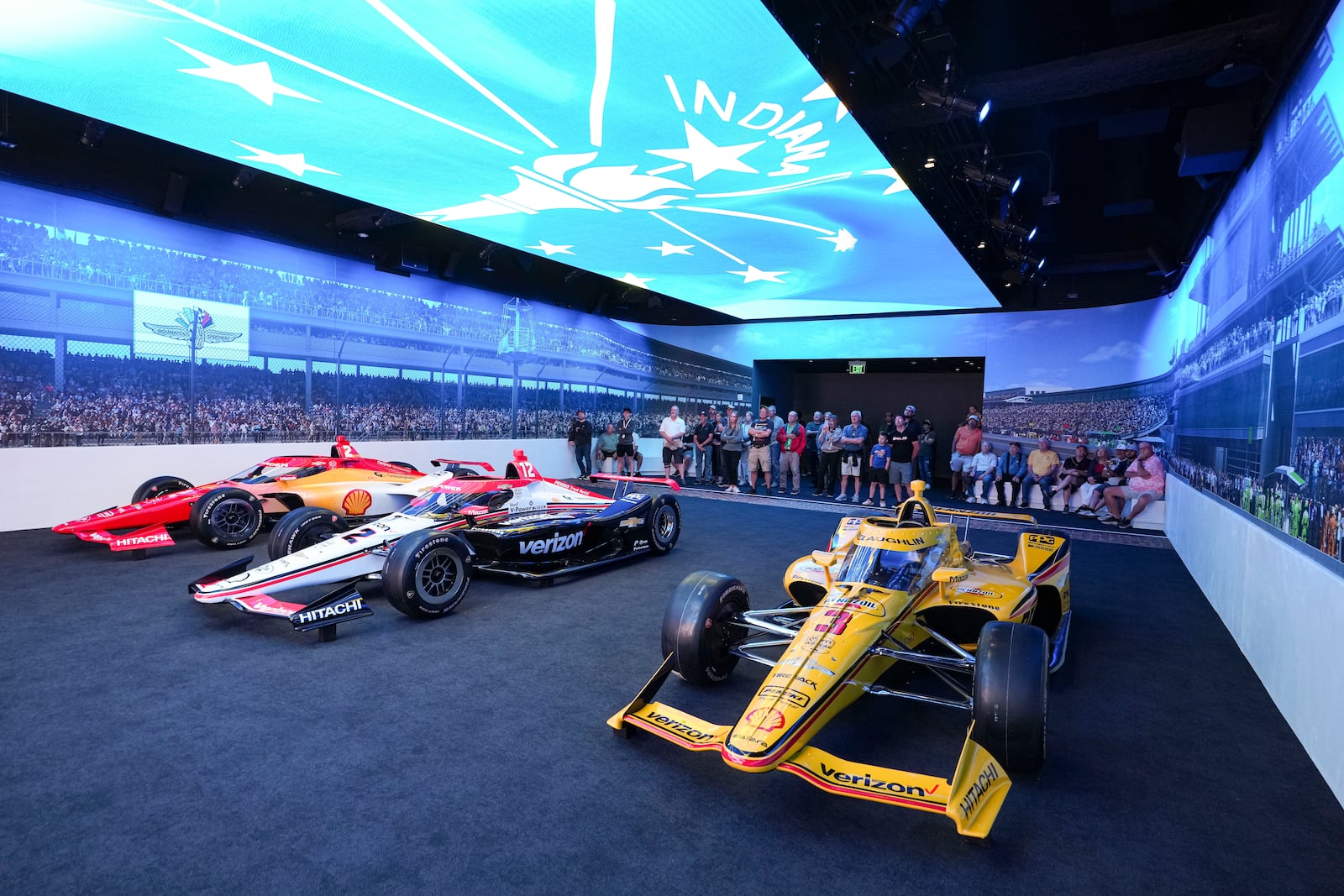Visitors to the Indianapolis Motor Speedway Museum watch the "Starting Grid Experience" at the Indianapolis Motor Speedway in Indianapolis, Monday, May 19, 2025. (AP Photo/Michael Conroy)
