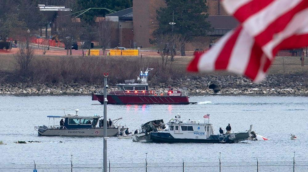 FILE - A diving team and police boat is seen near a wreckage site in the Potomac River, from Ronald Reagan Washington National Airport, Jan. 30, 2025, in Arlington, Va. (AP Photo/Jose Luis Magana, File)