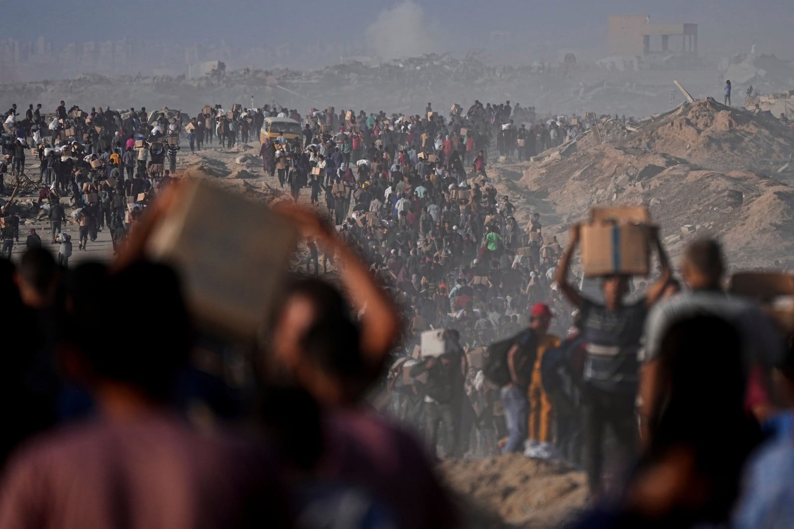 Palestinians carry sacks and boxes of food and humanitarian aid unloaded from a World Food Program convoy that had been heading to Gaza City, in the northern Gaza Strip, Monday, June 16, 2025. (AP Photo/Jehad Alshrafi)