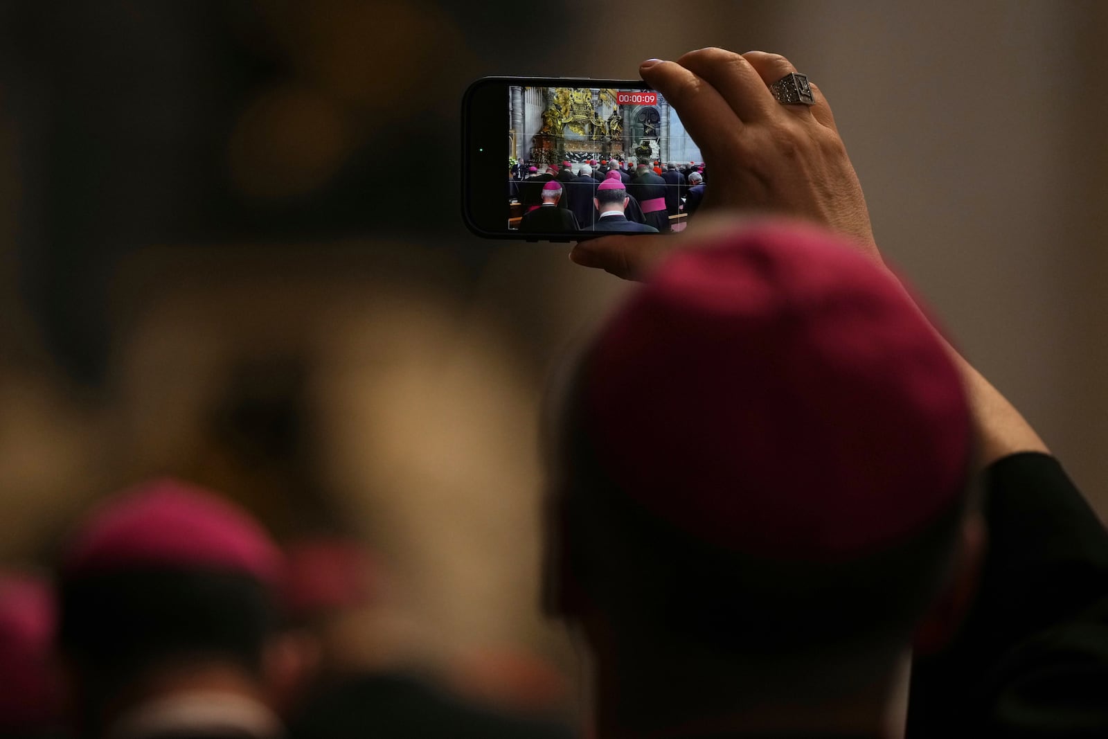 A Bishop takes photos as he attends the Pope Leo XIV leading a meditation with the participants into the Jubilee of Bishops inside St. Peter's Basilica, at the Vatican, Wednesday, June 25, 2025. (AP Photo/Andrew Medichini)