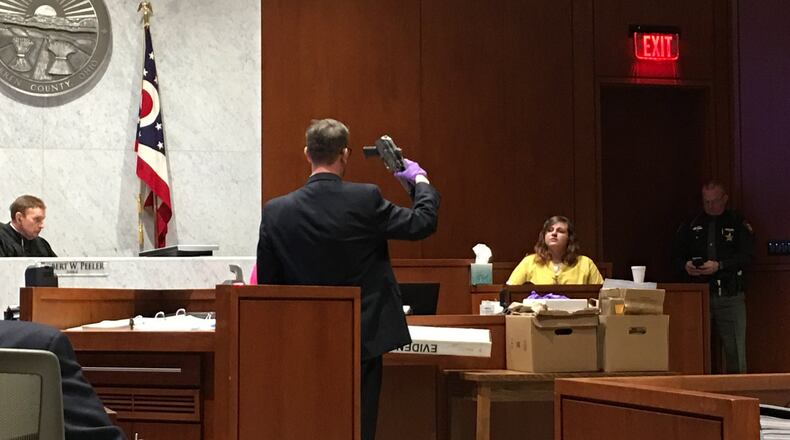 Assistant Warren County Prosecutor Travis Vieux holds up the AK-47 pistol allegedly used in a Christmas Day 2016 murder, while the victim’s cousin testified on Wednesday in Warren County Common Pleas Court.Staff photo by Lawrence Budd