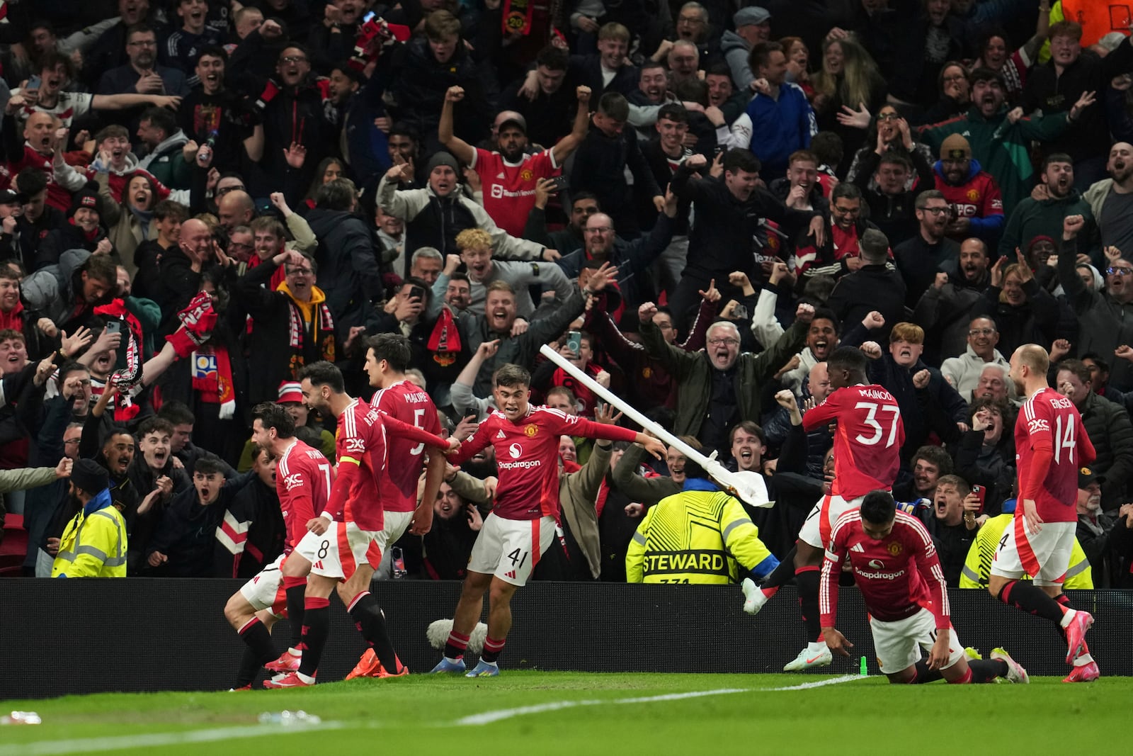 Manchester United's Harry Maguire, left, celebrates with team mates after his side's fifth goal during the Europa League quarter final second leg soccer match between Manchester United and Olympique Lyon in Manchester, Britain, Thursday, April 17, 2025. (AP Photo/Jon Super)