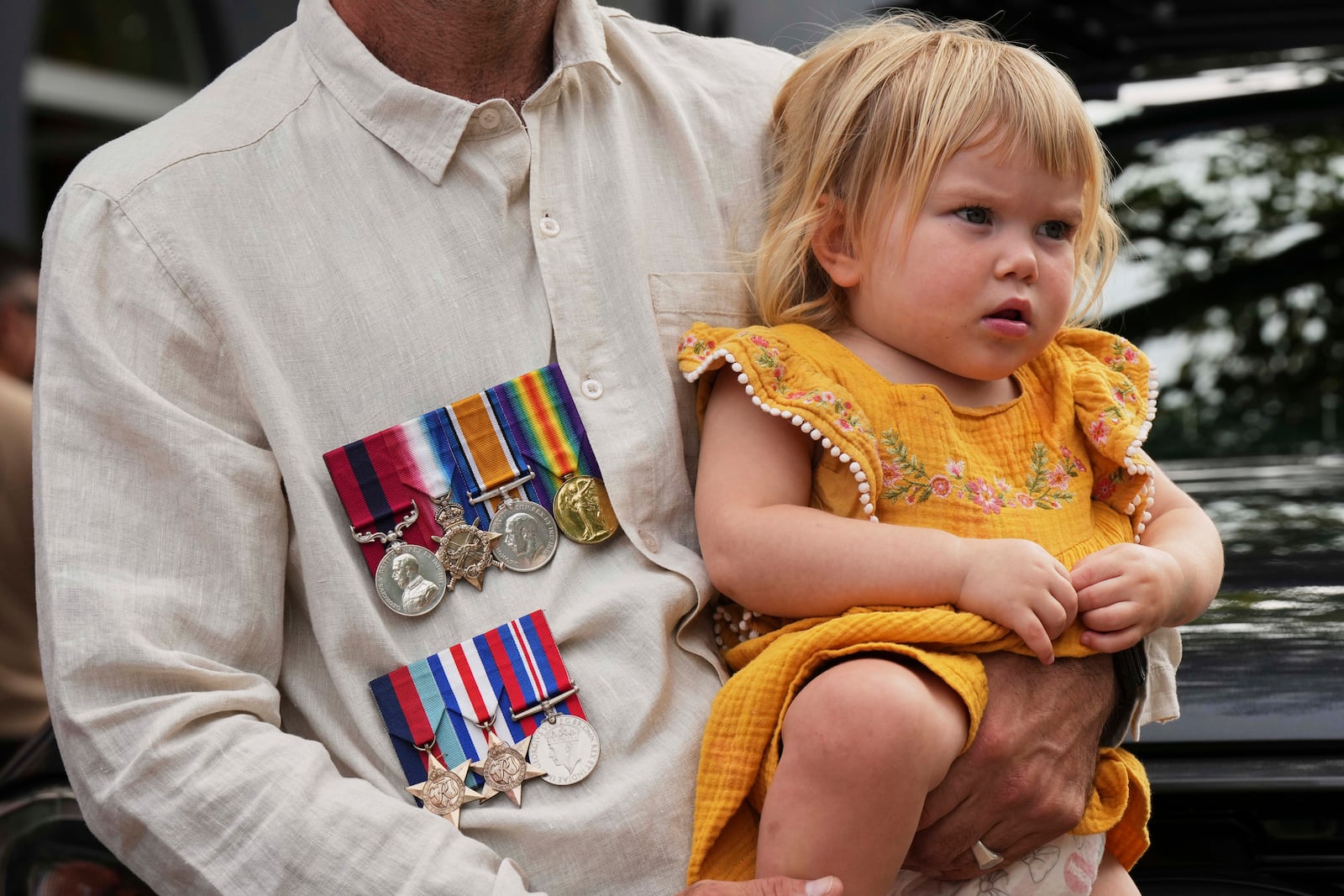 A father holds his child as during the Anzac Day commemorations in Nelson Bay, Australia, Friday, April 25, 2025. (AP Photo/Mark Baker)