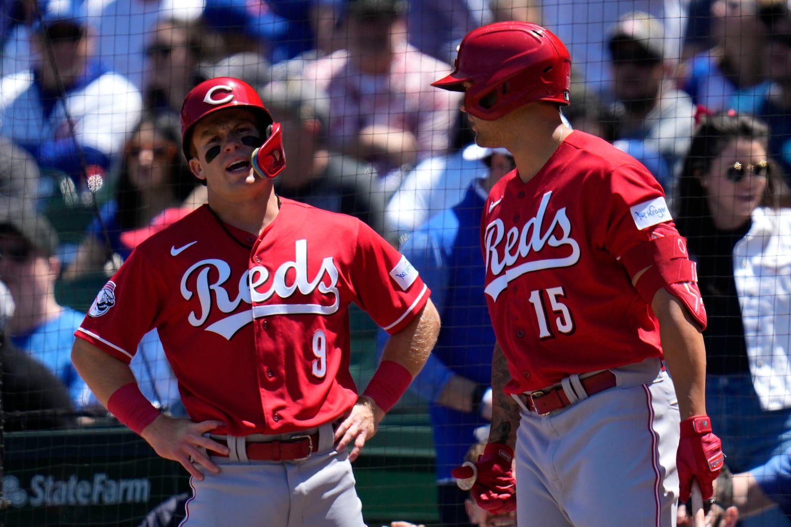 Cincinnati Reds' Matt McLain, left, talks with Nick Senzel after McClain scored a run during the first inning of a baseball game against the Chicago Cubs Friday, May 26, 2023, in Chicago. (AP Photo/Erin Hooley)