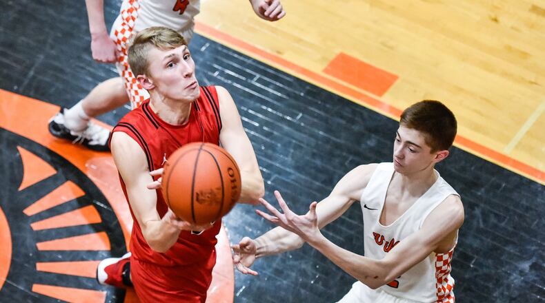 Madison’s Ryan Duritsch goes to the basket over Waynesville’s Bryce Nolbertowicz during Friday night’s game at Waynesville. The host Spartans won 59-39. NICK GRAHAM/STAFF