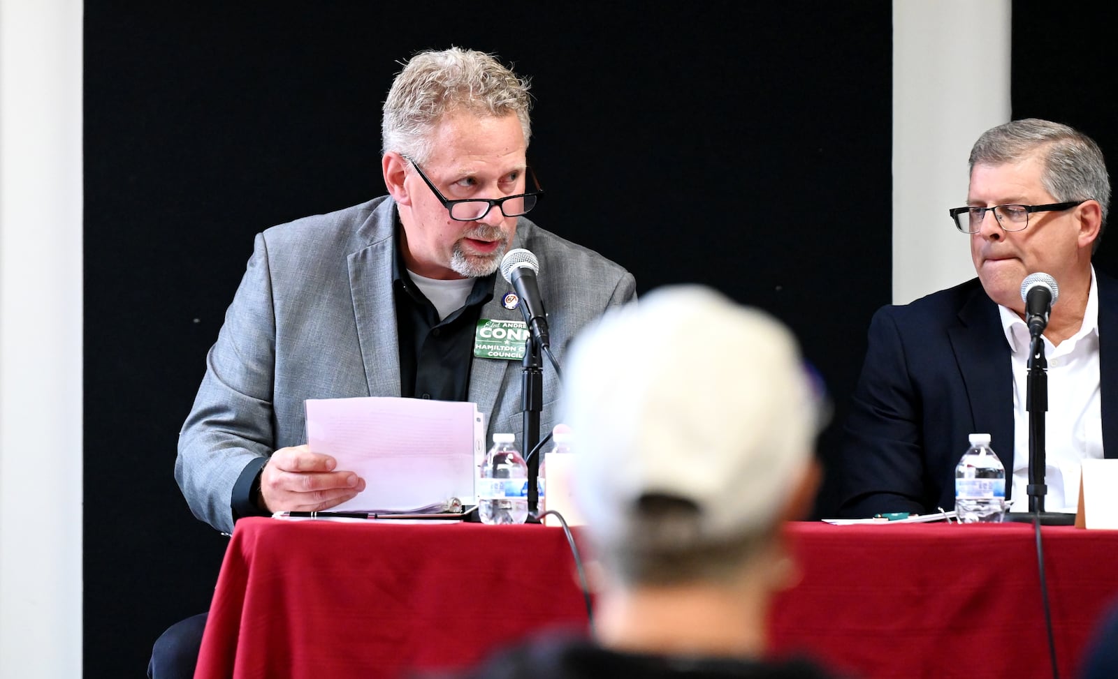 Five people are seeking three open seats on Hamilton City Council in the Nov. 4, 2025, general election. Pictured is candidate Andrew Conn (left) answering a question during a Sept. 24, 2025, candidates' forum hosted by the Greater Chamber of Commerce at Miami Downtown Hamilton Center on High Street. Also pictured is candidate Pat Bach listening. MICHAEL D. PITMAN/STAFF