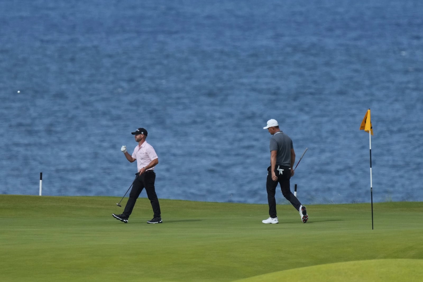 Li Haotong of China, right and Brian Harman of the United States walk on the 5th green during the third round of the British Open golf championship at the Royal Portrush Golf Club, Northern Ireland, Saturday, July 19, 2025. (AP Photo/Jon Super)