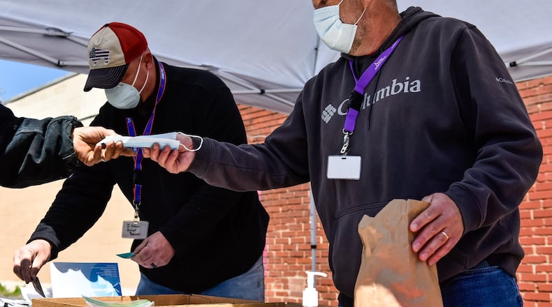 Scott Miller, left, director of community outreach with Access Counseling, and Daryl Hams, collaborative coordinator with Regional Exchange Project, set up on Crawford Street in Middletown for the needle exchange program Tuesday, April 21, 2020. They are handing out clean needles in exchange for dirty needles, giving masks, Narcan and other supplies. NICK GRAHAM / STAFF