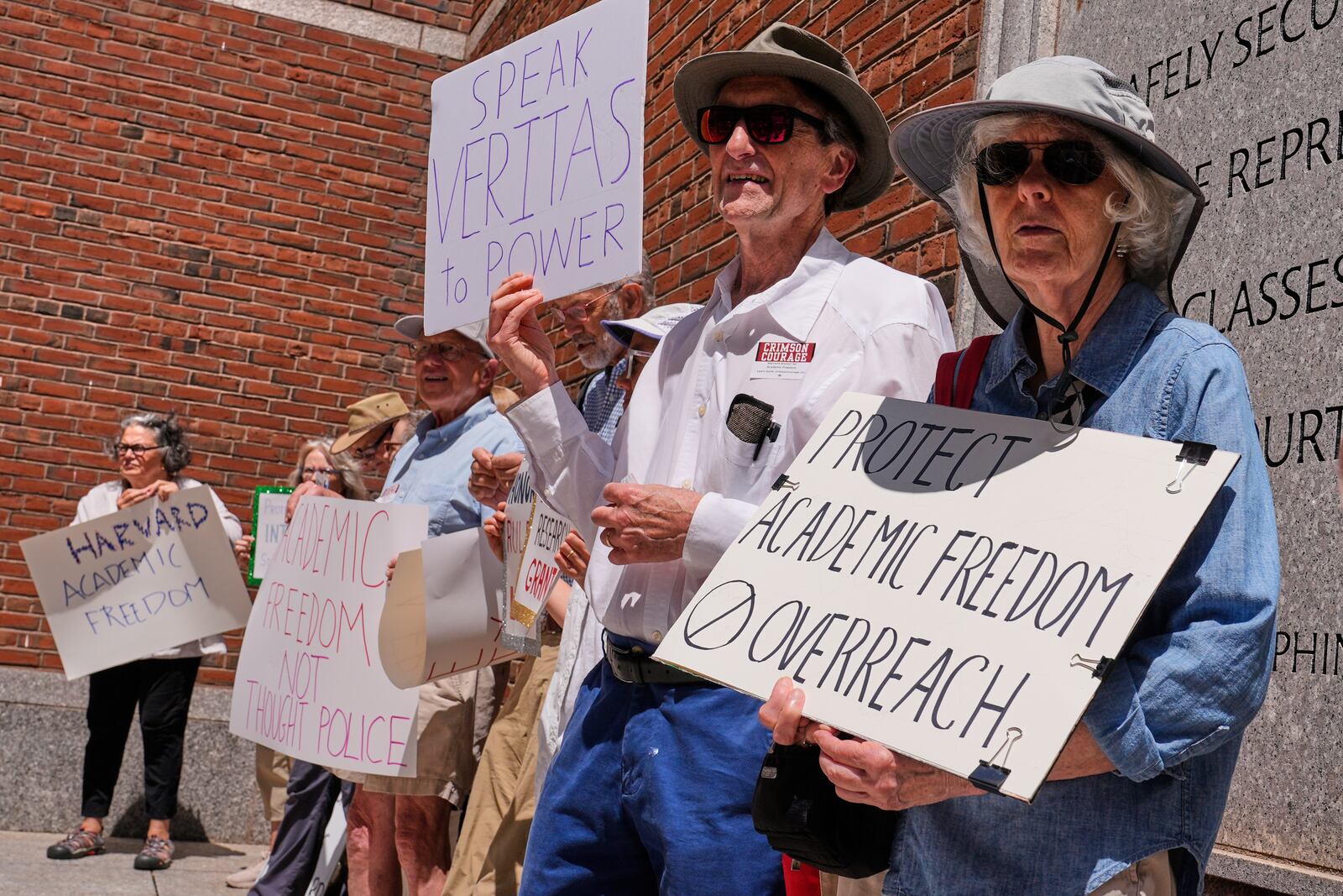 Protestors gather outside the Moakley Federal Courthouse, where Harvard University appeared to challenge $2.6 billion in funding cuts by the Trump administration, Monday, July 21, 2025, in Boston. (AP Photo/Charles Krupa)