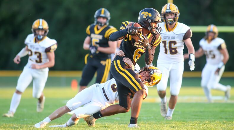 Shawnee High School junior Zion Crowe is tackled by Kenton Ridge senior Zach Thaxton after catching a pass during their game on Friday night in Springfield. The Braves won 34-7. Photo by Michael Cooper