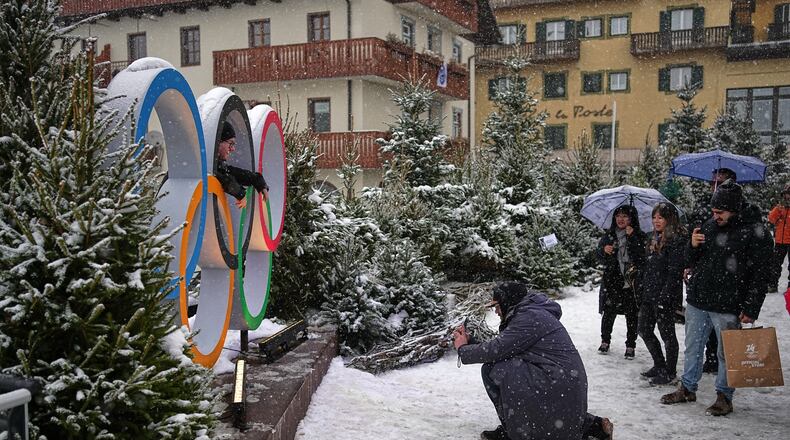 People take photos with the Olympic rings ahead of the 2026 Winter Olympics, in Cortina d'Ampezzo, Italy, Wednesday, Feb. 4, 2026. (AP Photo/Fatima Shbair)