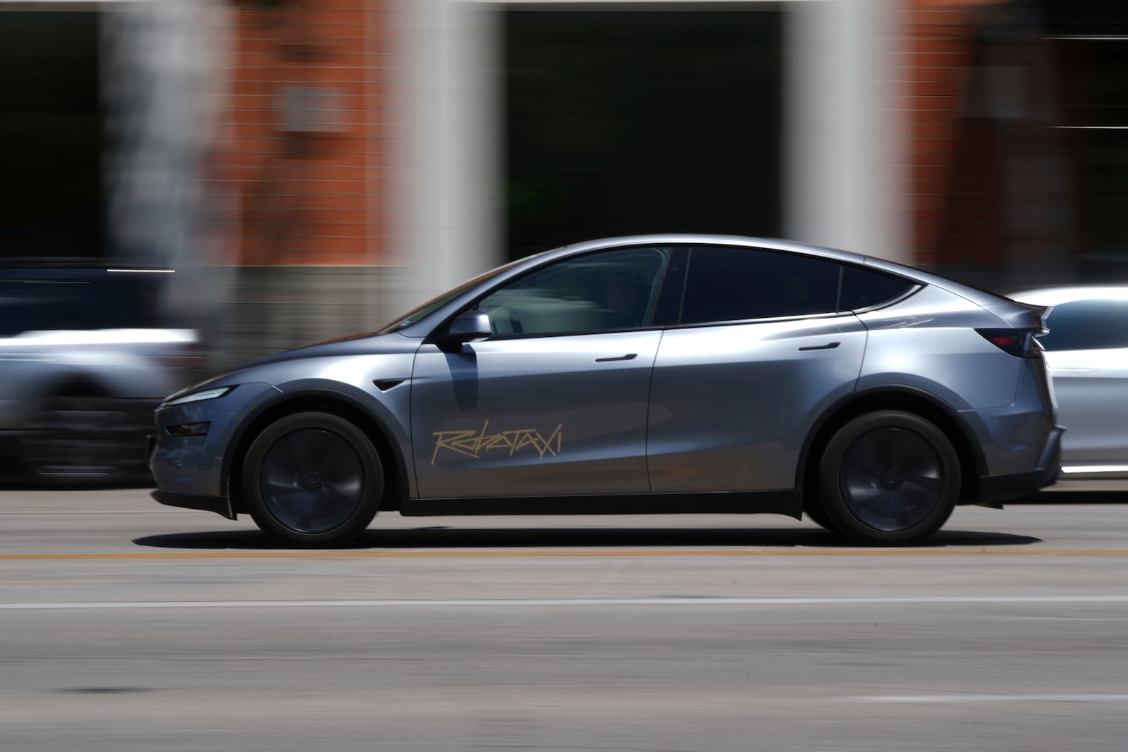 A driverless Tesla robotaxi, a ride-booking service, moves through traffic, Sunday, June 22, 2025, in Austin, Texas. (AP Photo/Eric Gay)