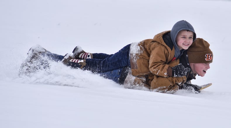 Cale Werth, 10, sleds down a hill with Owen Kairn, 5, on his back at Voice of America MetroPark Thursday, February 18, 2021 in West Chester Township. Many schools in the area were off for a snow day. NICK GRAHAM / STAFF