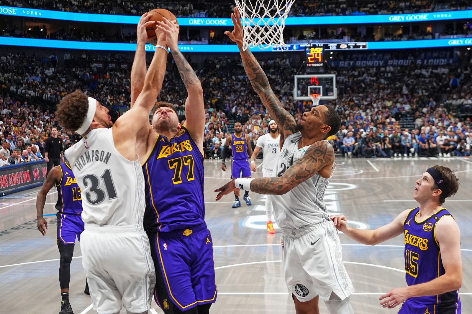 Los Angeles Lakers' Luka Doncic (77), Dallas Mavericks' Klay Thompson (31) and P.J. Washington, center right, compete for a rebound as Austin Reaves (15) looks on in the second half of an NBA basketball game in Dallas, Wednesday, April 9, 2025. (AP Photo/Julio Cortez)