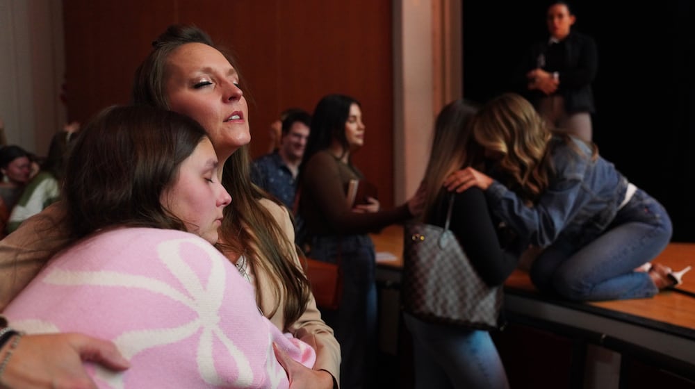 Angela Halili, 29, right, cohost of the Christian podcast, "Girls Gone Bible," prays over a follower during their live show held at the Atlanta Symphony Hall, Friday, Nov. 14, 2025, in Atlanta. (AP Photo/Jessie Wardarski)