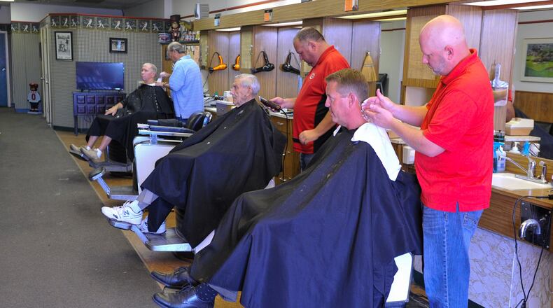 Ryan Haynes, right, owner of the Hamilton West Barber Shop, cuts Mike Schutter’s hair Tuesday, Aug. 28 in the The Hamilton West Shopping Center in Hamilton. The barber shop has been in the same shopping center for 50 years. After a remodeling, they will move into a former Chevron station nearby. NICK GRAHAM/STAFF