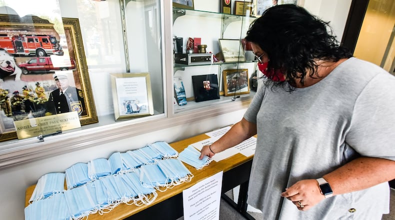 Monroe is considering a mandatory mask ordinance to help prevent the spread of coronavirus COVID-19. Last week, the Butler County Emergency Management Agency has partnered with fire departments around the county to make masks available Butler County residents. Carla Southard pics up masks for her family at the Fairfield Township Fire Department headquarters on Morris Road Friday, July 10, 2020. NICK GRAHAM / STAFF