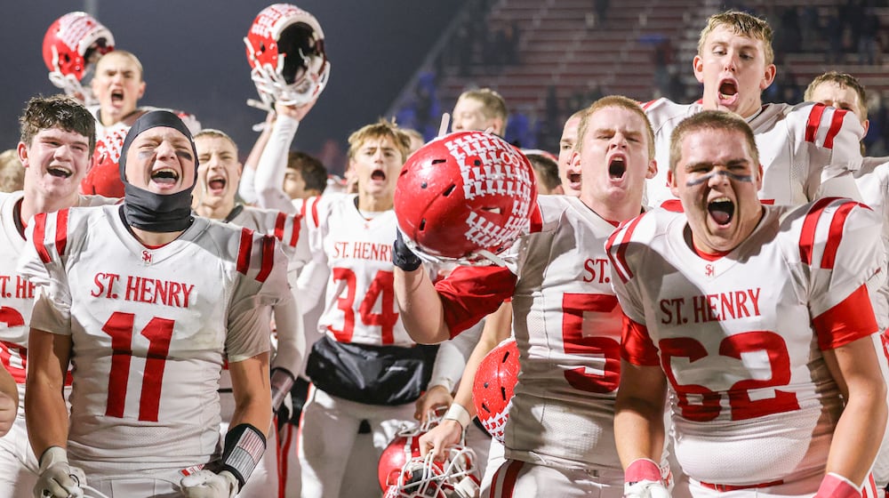St. Henry players celebrate after defeating Marion Local 24-7 in the Division VII, Region 28 championship on Friday, Nov. 21 at Mercy Health/Wapak Ford Field in Wapakoneta. The Redskins stopped a 76-game winning streak by their Midwest Athletic Conference rival Marion Local. BRYANT BILLING/STAFF