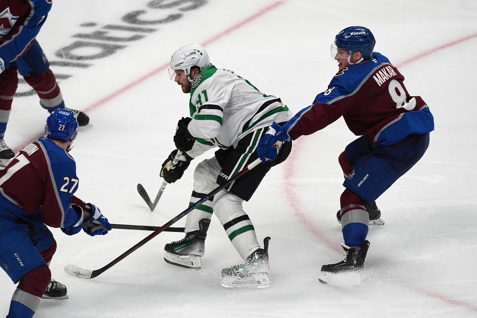 Dallas Stars center Tyler Seguin, center, drives past Colorado Avalanche defenseman Cale Makar, right, to shoot the puck past Colorado Avalanche left wing Jonathan Drouin for the winning score in overtime of Game 3 of an NHL hockey first-round playoff series Wednesday, April 23, 2025, in Denver. (AP Photo/David Zalubowski)