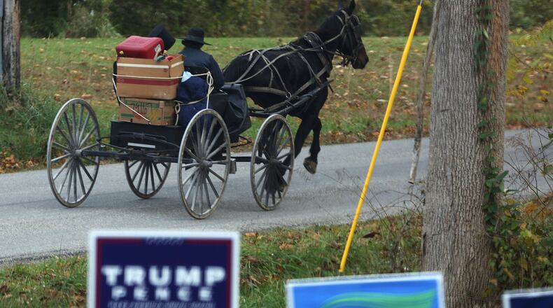 An couple ride in a horse and buggy down Mount Zwingli road in Fairfield County, Ohio, on October 27, 2016. (Columbus Dispatch photo by Brooke LaValley)