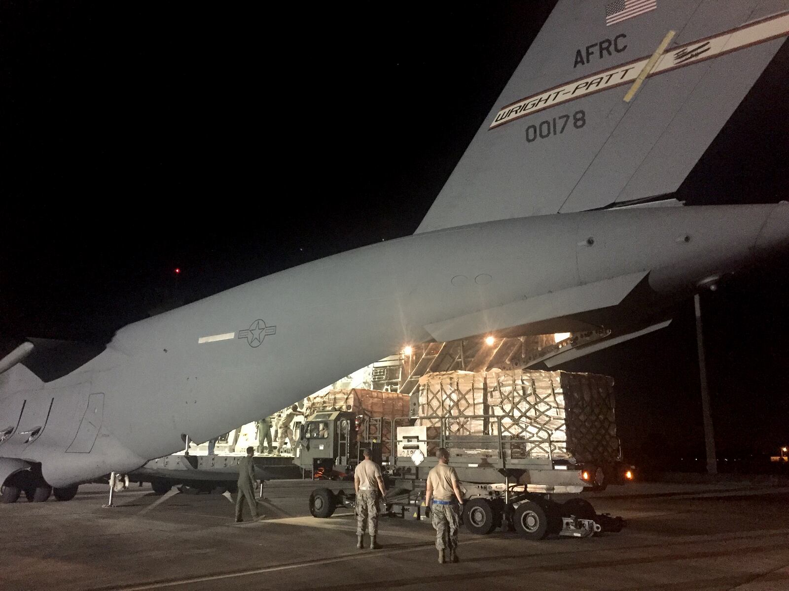 A Wright-Patterson Air Force Reserve C-17 crew unloads hurrican relief supplies at Homestead Air Reserve Base in Florida Tuesday night. BOB GARLOCK / STAFF
