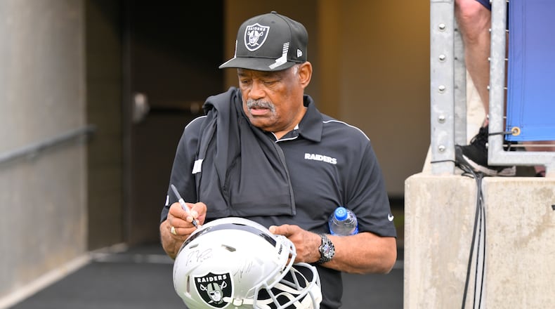 FILE - Former Oakland Raiders safety George Atkinson signs his autograph before the NFL football exhibition Hall of Fame Game between the Las Vegas Raiders and the Jacksonville Jaguars, Aug. 4, 2022, in Canton, Ohio. (AP Photo/David Richard, file)
