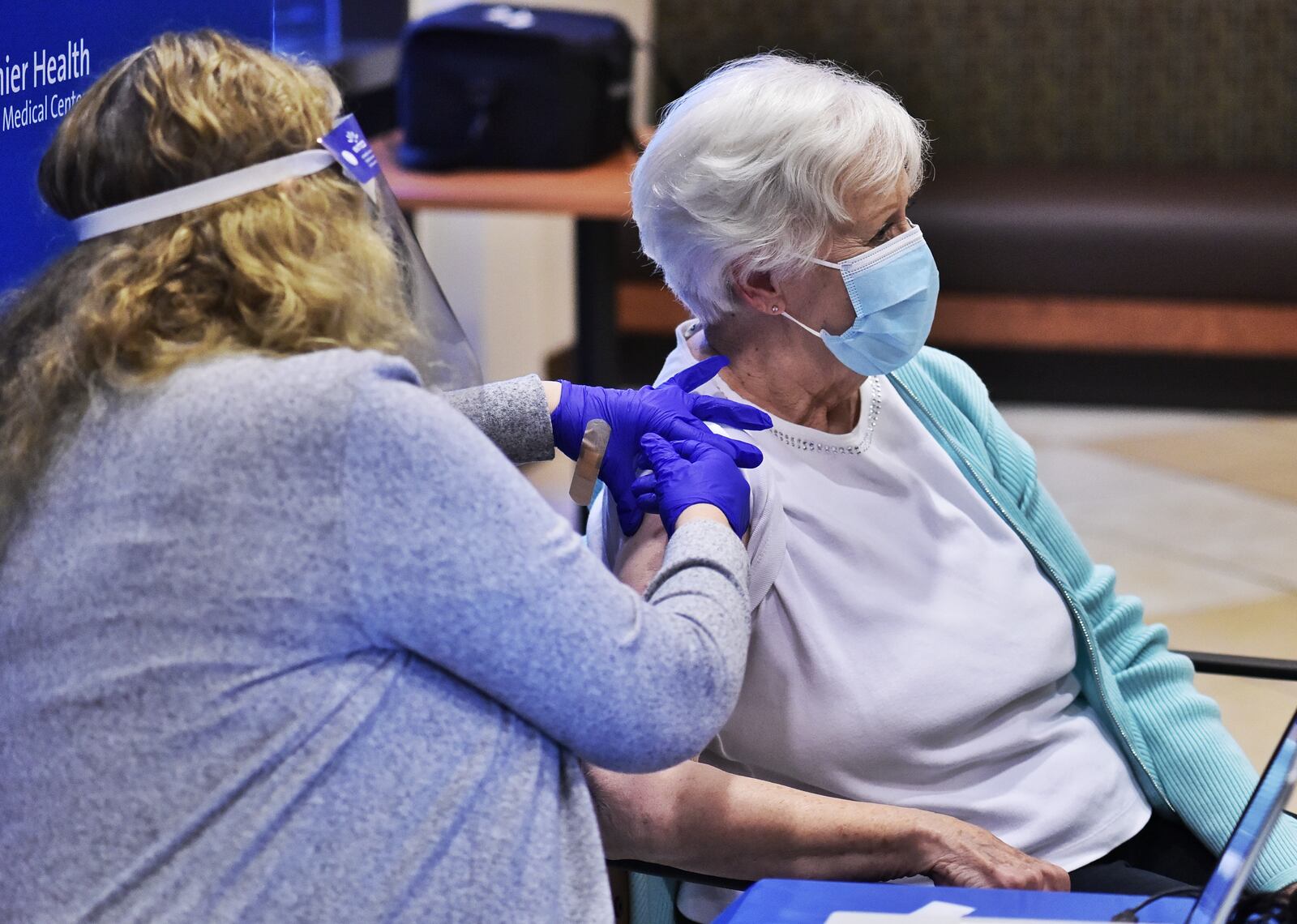 Atrium Medical Center LPN Tami Arnold administered one of their first Phase 1B COVID vaccines to Donna Wilson on Jan. 19. She was the person vaccinated at the hospital. Pfizer vaccines were given to five people during this media event. NICK GRAHAM / STAFF
