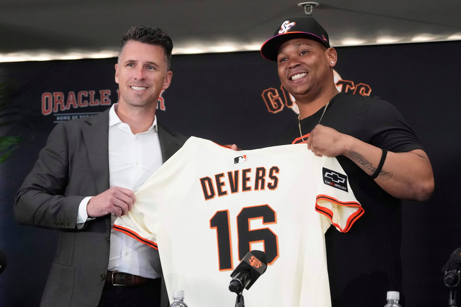 San Francisco Giants' Rafael Devers, right, poses for photos with President of Baseball Operations Buster Posey at a news conference before a baseball game between the Giants and the Cleveland Guardians in San Francisco, Tuesday, June 17, 2025. (AP Photo/Jeff Chiu)