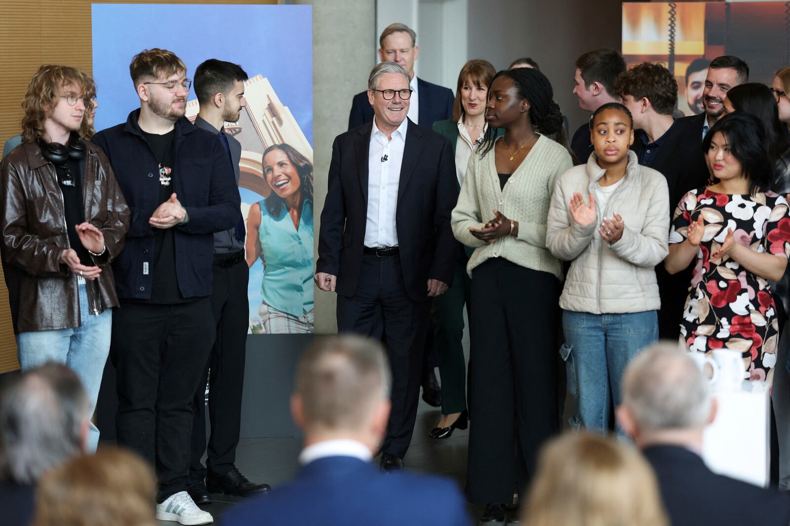 People applaud as British Prime Minister Keir Starmer attends an announcement that U.S. media giant Comcast Corp will build its first Universal theme park and resort in Europe, opening in 2031, during a visit to Bedford, north of London, Wednesday April 9, 2025. (John Sibley/Pool Photo via AP)