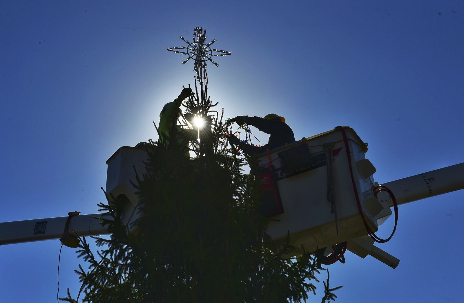 Hamilton city employees decorate a Christmas tree that was erected at Marcum Park. The tree was donated by Gary and Donna Trudel. NICK GRAHAM/STAFF
