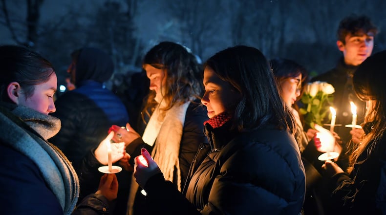 FILE - People hold candles during a vigil, Dec. 14, 2025, in Providence, R.I., for the victims of Saturday's shooting on the campus of Brown University. (AP Photo/Steven Senne, File)