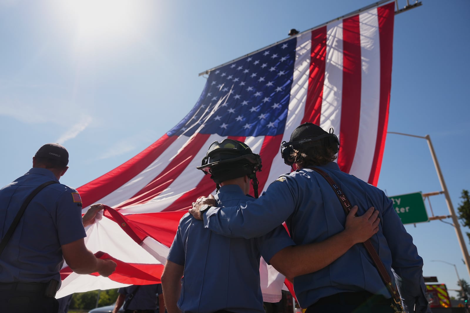 The Coeur d'Alene Fire Dept. hangs an American flag to honor the firefighters who were killed Sunday, in Coeur d'Alene, Idaho, on Tuesday, July 1, 2025. (AP Photo/Lindsey Wasson)