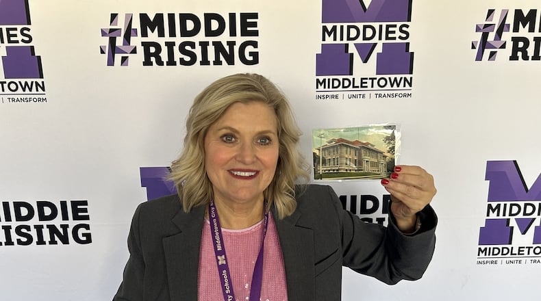 Middletown Superintendent Deborah Houser shows off a 109-year-old postcard of the first Middletown High School in the city. The district received the postcard from a collector in California. SUBMITTED PHOTO