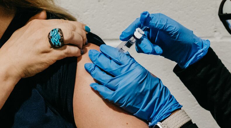 FILE — A COVID-19 booster is administered at the Portage Park Senior Center in Chicago, Sept. 13, 2022. In nearly two dozen interviews by The New York Times, voters who like Robert F. Kennedy Jr. say he shares their grievances about health care and share their interest in alternative medicines and natural remedies. (Jamie Kelter Davis/The New York Times)