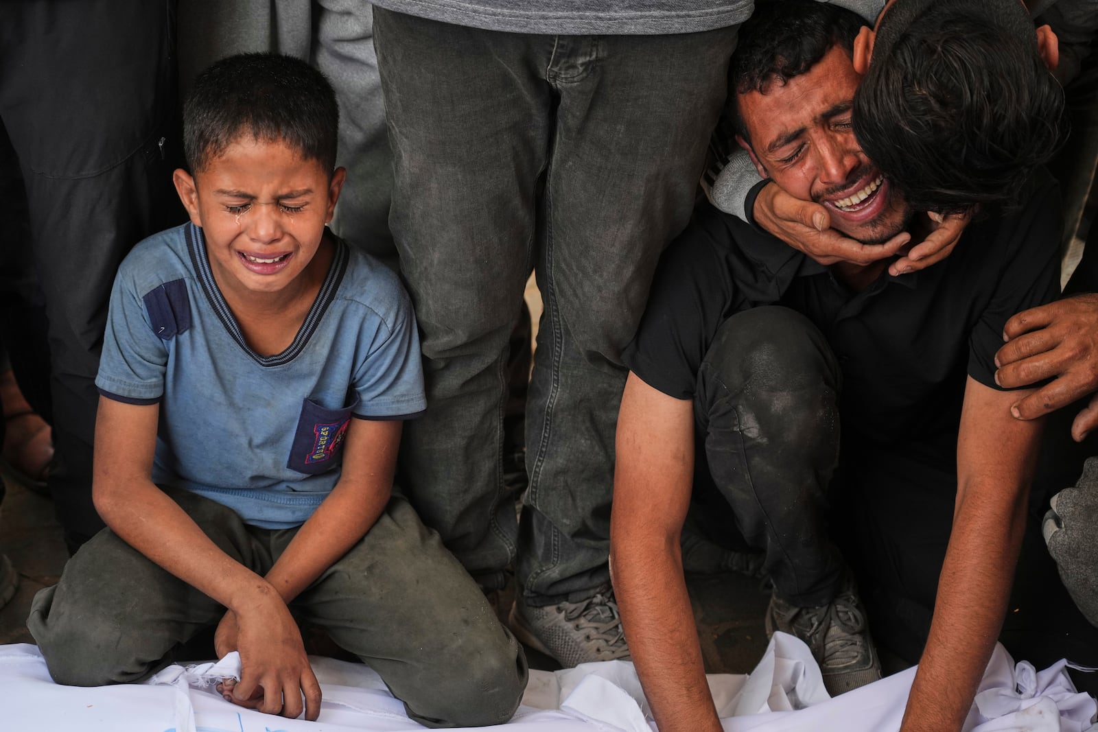 Relatives react as they mourn over the body of a loved one killed, along with others, in Israeli strikes on the Gaza Strip, at Al-Shifa Hospital in Gaza City, Saturday, June 28, 2025. (AP Photo/Jehad Alshrafi)